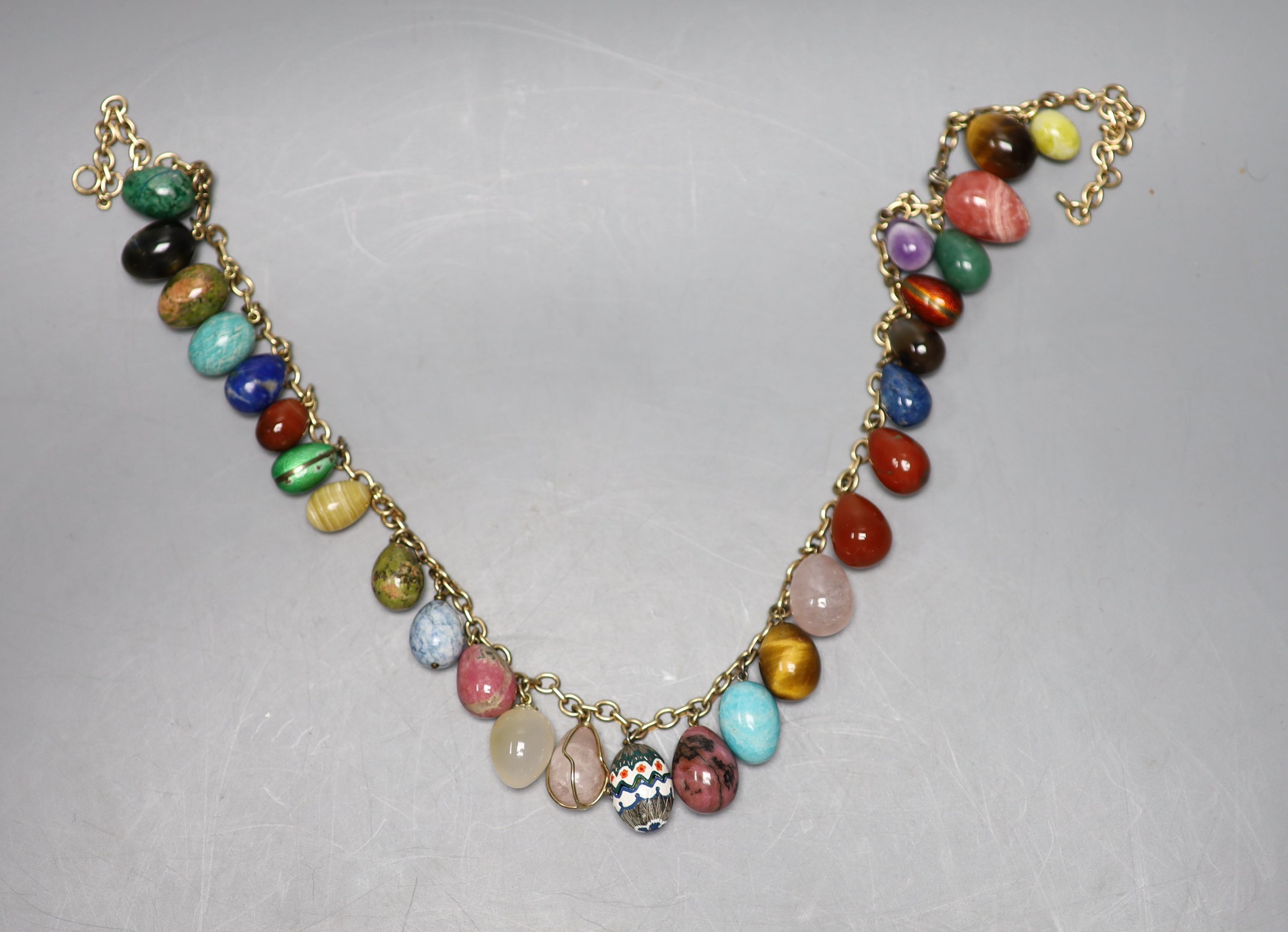 A 9ct gold and egg shaped specimen hardstone and enamelled charm set necklace, 70cm, gross weight 198.6 grams.